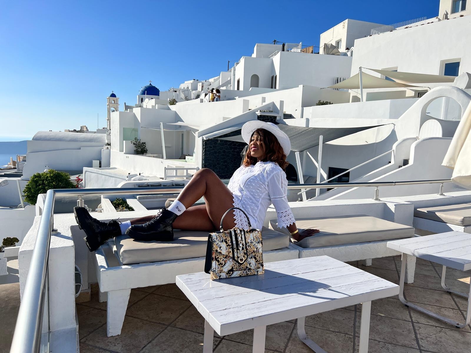 Traveller relaxing on a sun lounger among the white houses of Santorini